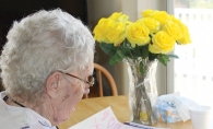 A senior at Woodbury Senior Living reads a handwritten holiday letter.