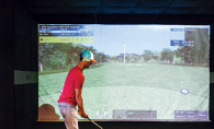 A golfer plays a virtual golf simulation at X-Golf in Woodbury.