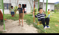A volunteer with Woodbury nonprofit Milk and Honey Missions pushes children from the Honduran village of Villa San Antonio on a swing.