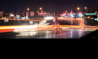 A long exposure photograph shows the city lights and cars on Radio Drive in Woodbury.