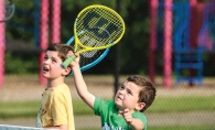 Two children on the court at Little Spikers tennis clinic.