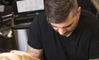 Aaron Michael tattoos a customer at Aloha Art Collective, a tattoo shop in Woodbury