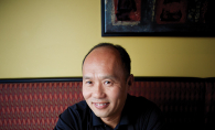Duc's Restaurant owner Duke Kim sits in front of some of his food.