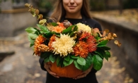 A woman holding an autumnal bouquet.