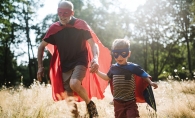 A grandfather and grandson play superheroes