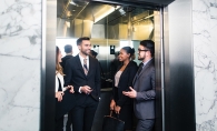 A group of people ride on an elevator.