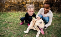 Two children play with a dog at Coco's Heart Dog Rescue Academy.