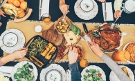 A family gathers around a table for Thanksgiving dinner