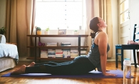 A woman does yoga in her living room.