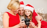 A mother, father and daughter review their family holiday photos