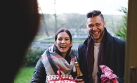 A couple brings wine and presents to a family Christmas gathering.