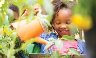 A child tends to a Garden Box at Woodbury YMCA.