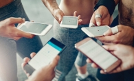 A group of people look at their phones, planning their weekly fitness routines.