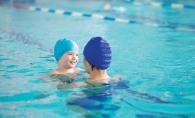 Mother and child swimming in a pool.