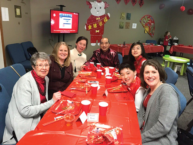 A family gathers around a table at Salem Lutheran Church's Chinese New Year celebration.