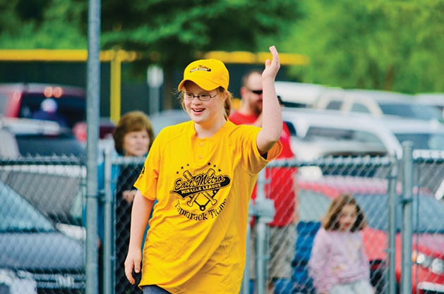A girl raises her hand at an East Metro Miracle League game.