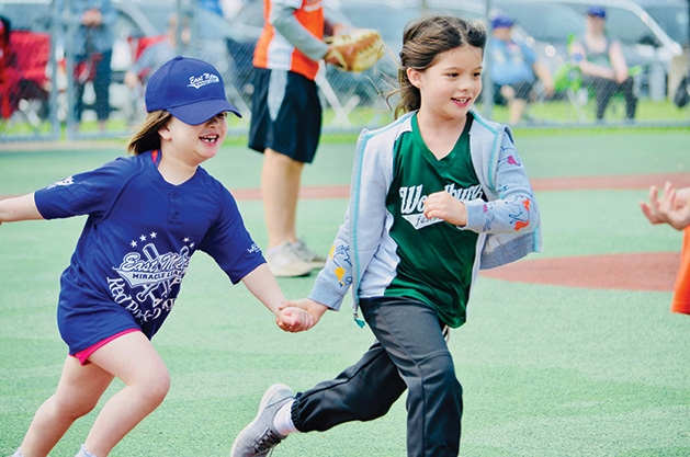 Two players run at an East Metro Miracle League game.