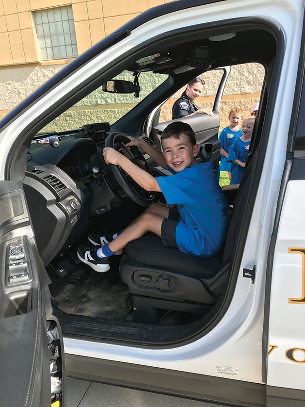 A child sits behind the wheel at Half Pint Safety Camp