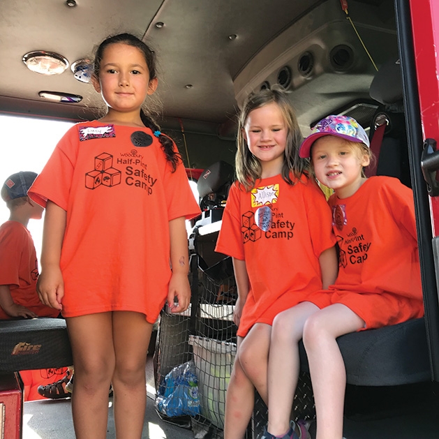 Kids sit in a car at Half Pint Safety Camp