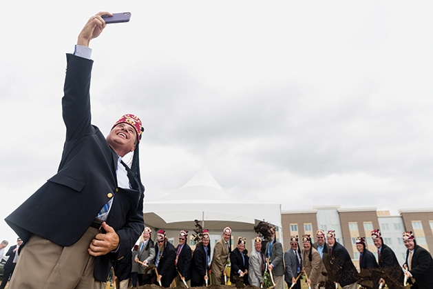 A man takes a group selfie at the Shriners Healthcare for Children groundbreaking in Woodbury