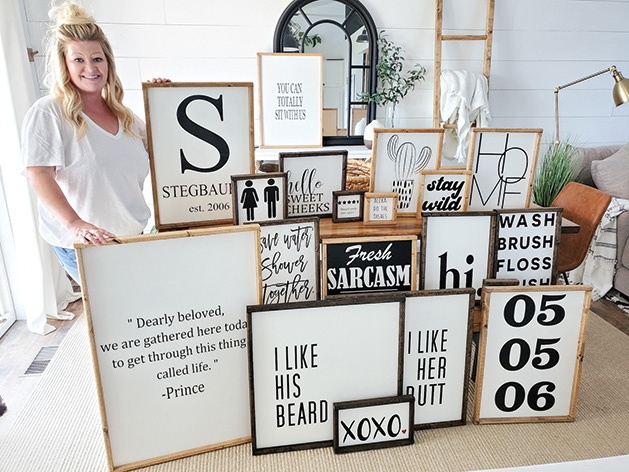 Jessica Stegbauer, owner and creator behind Rusty7s, shows off some of her handmade signs.