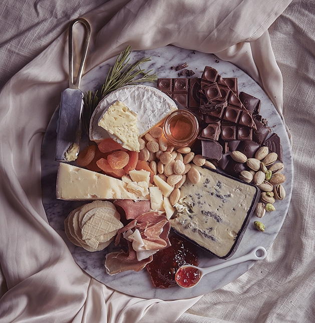 A Valentine's Day platter featuring, cheese, chocolate and other snacks.