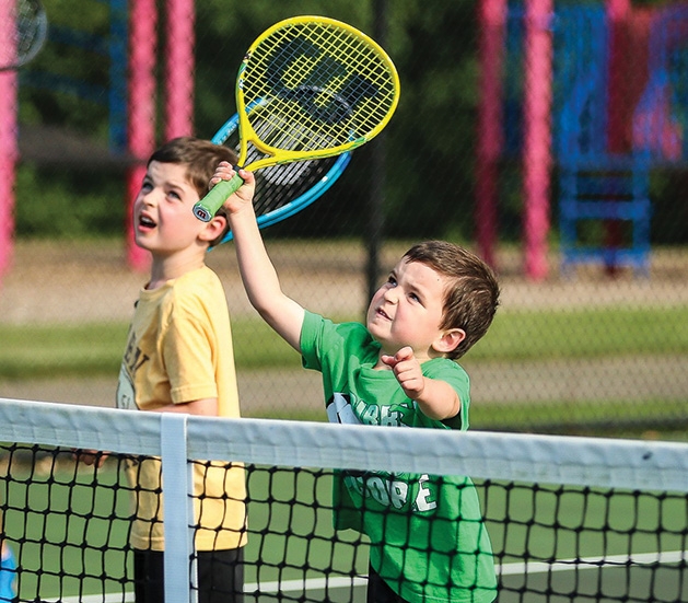 Two children on the court at Little Spikers tennis clinic.