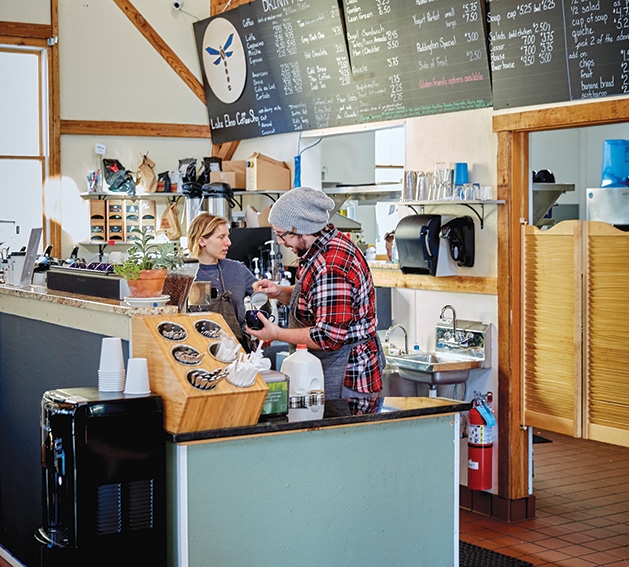 Two baristas stand behind the counter at Lake Elmo Coffee