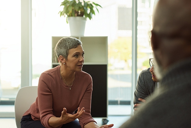 A woman speaks to a group of people.