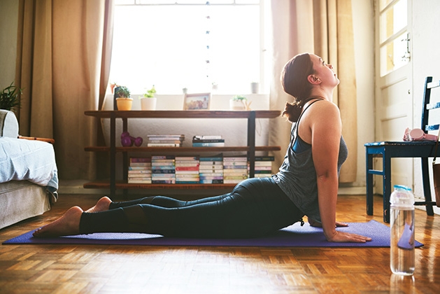 A woman does yoga in her living room.