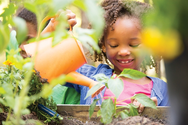 A child tends to a Garden Box at Woodbury YMCA.