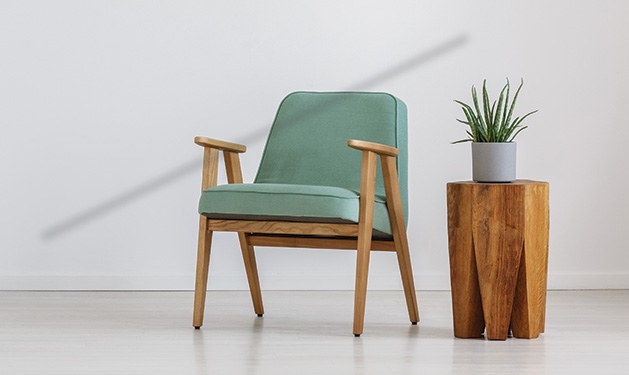 Two pieces of sustainable furniture - a chair and a side table - in a living room.