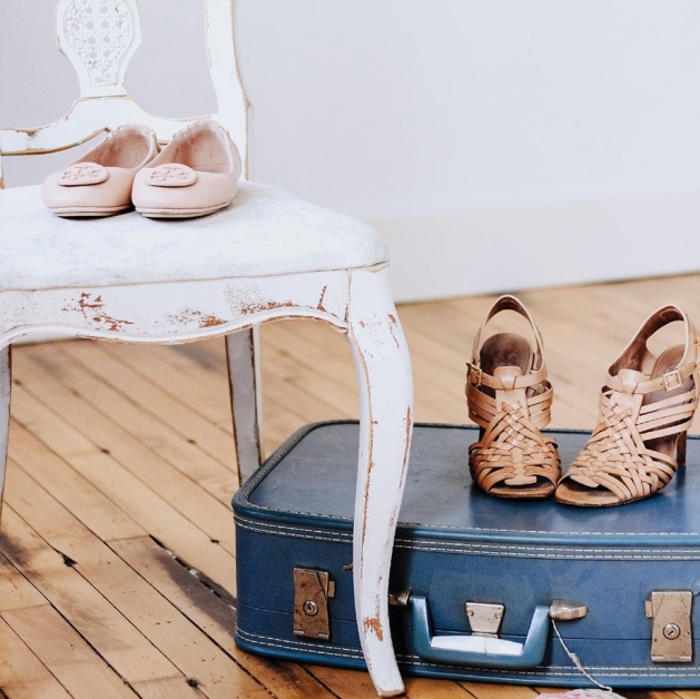 Shoes on top of a suitcase.