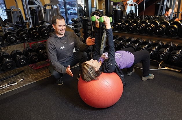 Jacek Kozdroj guides a client through an exercise at Anytime Fitness in Woodbury.