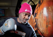 Mike Lewis, owner of 3P Boxing 24/7, punches a punching bag.