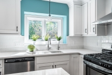 An alcove over a kitchen sink painted light teal.
