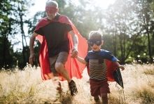 A grandfather and grandson play superheroes