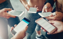 A group of people look at their phones, planning their weekly fitness routines.