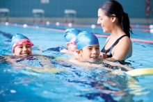 Woman instructor and young swim students.