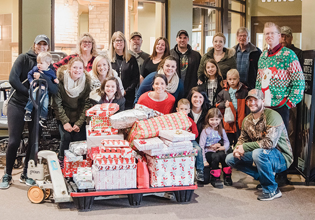 A group of volunteers from nonprofit Best Christmas Ever deliver gifts to a family in need.