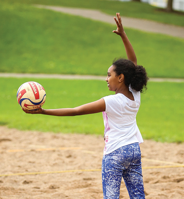 A child prepares to serve at Big Spikers volleyball clinic at Crosswind E-STEM Middle School.