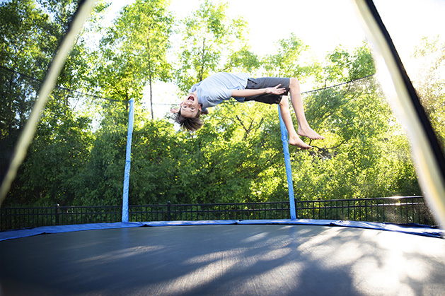 A boy mid-jump on a trampoline.
